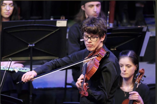 Alex playing a viola solo in Háry János Suite - Zoltán Kodály, in ACT Youth Orchestra concert 2022, directed by Rowan Harvey-Martin. Photo by Peter Hislop.